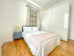 Habitación blanca con cama y ventana en Gower street residences en Londres
