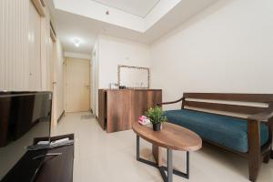 a bedroom with a bed and a table and a tv at RedLiving Apartemen 19 Avenue - Reza Property in Porisgaga +43 photos