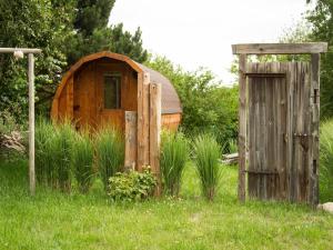 een houten schuur en een houten deur in het gras bij Haus Ostseerose - Ferienwohnungen Florentine, Linus, Ostseerose in Hagen