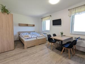 sypialnia z łóżkiem, stołem i krzesłami w obiekcie Restaurace a penzion Gansberg w mieście Cotkytle