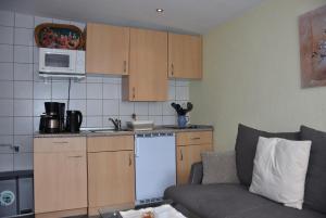 eine kleine Küche mit einem Sofa und einer Mikrowelle in der Unterkunft Karlshagen - Lissis Feriendomizil in Ostseebad Karlshagen