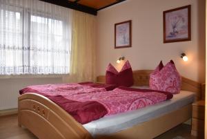 ein Schlafzimmer mit einem großen Bett mit rosafarbenen Laken und Kissen in der Unterkunft Karlshagen - Lissis Feriendomizil in Ostseebad Karlshagen + 5 Fotos