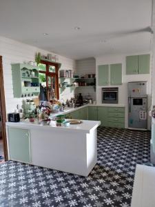 una cucina con armadi verdi e piano di lavoro bianco di Chalet Ohana, airport family house a Faaa