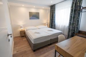um pequeno quarto com uma cama e uma mesa em Pura Vida House – Bükfürdő em Bük