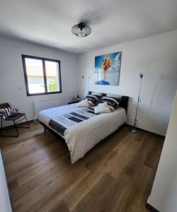 a bedroom with a large bed and wooden floors at appartement 40 m 2 in Pérols