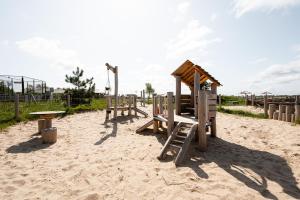 a playground with benches and a table in the sand at Glamping Schotsman in Kamperland
