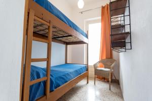 a bedroom with a bunk bed and a chair at Appartamento Selinunte in Marinella di Selinunte