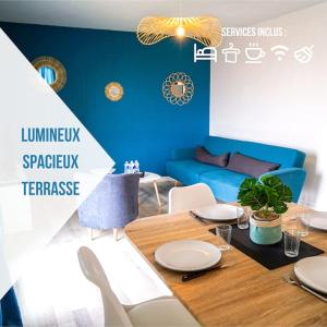 a dining room with a table and a blue wall at L'Eden Urbain・Stationnement Facile・Proche Centre in Châteauroux