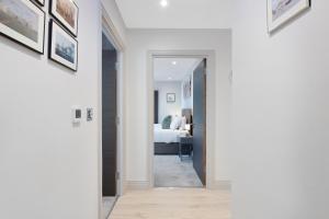 a hallway leading to a bedroom with a bed at Spacious, 3 bedroom, 2 bathroom, Surbiton in Surbiton