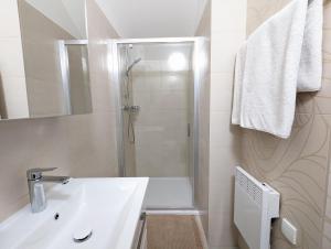 a white bathroom with a shower and a sink at Restaurace a penzion Gansberg in Cotkytle