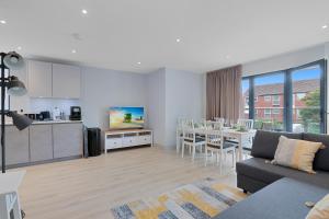 a living room with a couch and a kitchen and a table at Spacious, 3 bedroom, 2 bathroom, Surbiton in Surbiton