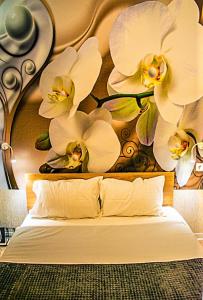 un dormitorio con un cabecero con flores blancas. en AyaSofiA Suite HOT TUB- JAKUZZI, balcons 2 rooms and 1 luxury Studio, en Tesalónica