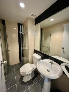 La salle de bains est pourvue d'un lavabo, de toilettes et d'un miroir. dans l'établissement Top High Airport Link Hotel, Bangkok, à Bangkok
