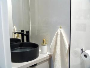 uma casa de banho com um lavatório preto e um espelho em ZB Apartment BEIGE Piekary Śląskie em Piekary Śląskie