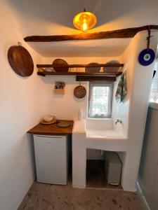 a small bathroom with a sink and a window at Rizes Mykonos - Folklore Farmstead in Mýkonos City