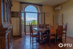 ein Esszimmer mit einem Tisch und einem großen Fenster in der Unterkunft PoloTuristicoUmbria Villa del Maestrale in Perugia
