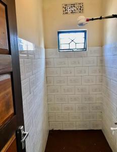 łazienka z prysznicem i oknem w obiekcie Nomads nest safari house w mieście Arusza