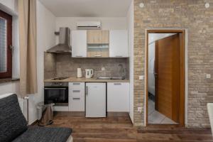 a kitchen with a white refrigerator and a sink at Apartments Hablando in Pridraga