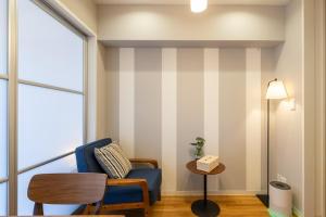a waiting room with a blue chair and a table at H2H Tsutenkaku in Osaka