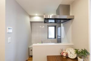 a kitchen with a sink and a counter with a clock at H2H Tsutenkaku in Osaka +50 photos
