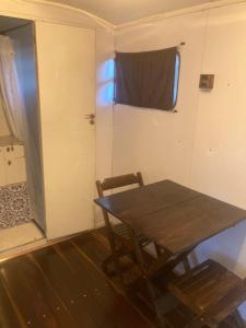 a room with a table and a door with a window at Salamandra trailerhome in Pirenópolis