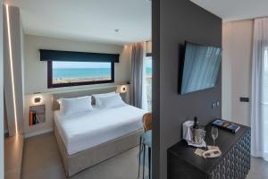 a hotel room with a bed and a television at Savoy Beach Hotel & Thermal Spa in Bibione