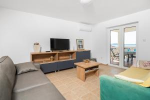 ein Wohnzimmer mit einem Sofa und einem TV in der Unterkunft Rimagis Apartments in Zaboric