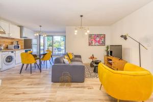 uma sala de estar com um sofá e cadeiras amarelas em Belles prestations, 3 ch, terrasse, wifi fibre em Grenoble