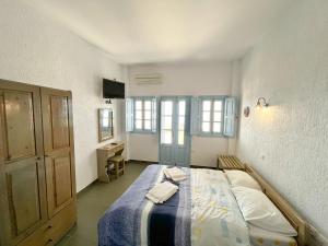 een slaapkamer met een bed met een blauwe deken bij Panorama Oia Apartments in Oia