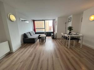 a living room with a couch and a table at Full Apartment! Brick Lane! in London