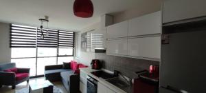a kitchen with white cabinets and pink pillows at Tips For istanbul in Istanbul