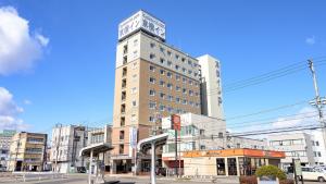 a tall building with a clock on top of it at Toyoko Inn Tochigi Ashikaga eki Kita guchi in Ashikaga