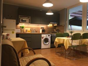 a kitchen with a table and chairs and a kitchen with a washing machine at Mandula Vendégház in Eger