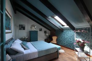 1 dormitorio con 1 cama grande y tragaluz en Bed & Brekfast da Kate Dreams and Colors, en Foglizzo