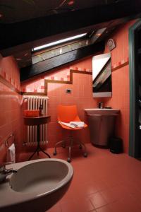 baño con silla naranja y lavamanos en Bed & Brekfast da Kate Dreams and Colors, en Foglizzo