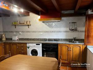 cocina con lavadora y fregadero en Vivienda vacacional El Cau - Casas de Los Picos, en Ruenes