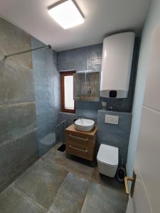 y baño con lavabo, aseo y ducha. en Apartmani Meštrović, en Drage