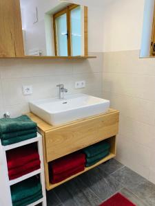 La salle de bains est pourvue d'un lavabo, d'un miroir et de serviettes. dans l'établissement Ferienhaus Lemsitz 34, 