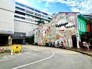 un edificio cubierto de graffiti al lado de una calle en Arena eSports @ Orchard en Singapur