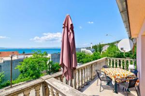 a balcony with a table and an umbrella at Apartment in Crikvenica with One-Bedroom 3 in Crikvenica