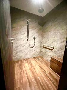 a shower in a bathroom with a wooden floor at Arena eSports @ Orchard in Singapore