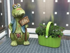 a frog statue sitting on a table next to two plants at Gästehaus Durst in Rust
