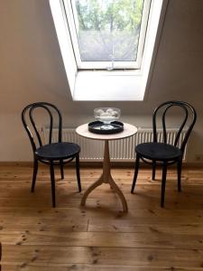 a table and two chairs in a room with a window at McIntosh 