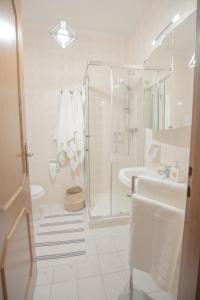 een witte badkamer met een douche en een wastafel bij Casa Vacanza di Monica in Bordighera