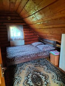 a bedroom with a bed in a wooden cabin at "Бджілка" in Lyuta