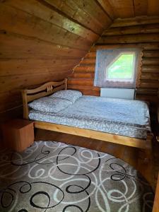 a bedroom with a bed in a log cabin at "Бджілка" і " Садиба для відпочинку" in Lyuta