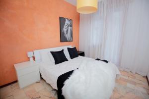 een slaapkamer met een wit bed en een oranje muur bij Casa Vacanza di Monica in Bordighera