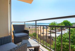 a balcony with chairs and a table and a view of the ocean at Royal Marina Beach in Chernomorets