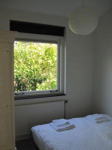 エグモント・アーン・デン・フフにあるDe Zeemeeuwのベッドルーム(ベッド1台、窓付)