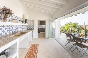 una cucina con piastrelle bianche e blu e un tavolo da pranzo di Estoril Contemporary Garden Villa by CadenzaLux a Cascais